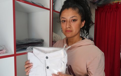 Quito. Candy Bayas sostiene una prenda de vestir en su local.