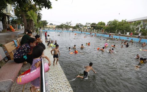 Las personas toman un refrescante baño por las altas temperaturas.