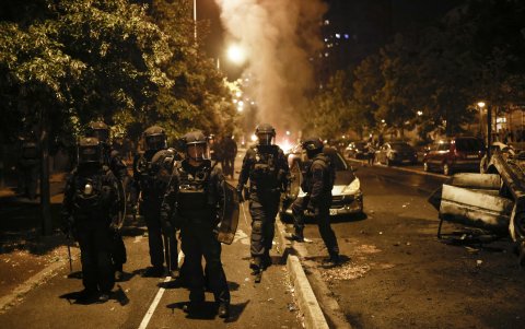 Policías antidisturbios junto a un vehículo incendiado en las protestas en Nanterre (France).