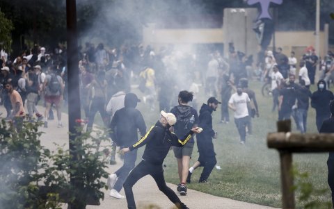 Un manifestante arroja una piedra durante los enfrentamientos con la policía antidisturbios francesa tras una marcha en memoria de Nahel, de 17 años, asesinado por la policía francesa en Nanterre.