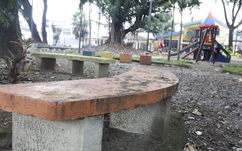 Los bancos de cemento están despintados y desportillados. Nadie los usa.