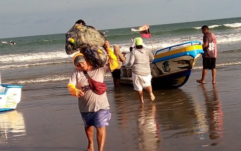 Playas. Un pescador carga la pesca que logró hacer en una jornada de trabajo.