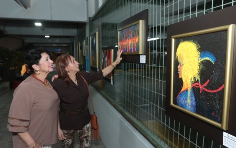 Amanda León  y Vilma de Amador admiran Los muros de la naturaleza, obra de Gisella de Chávez.
