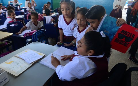 Dedicación. Clara Celi revisa las tareas de sus alumnos, quienes de forma ordenada facilitan el trabajo