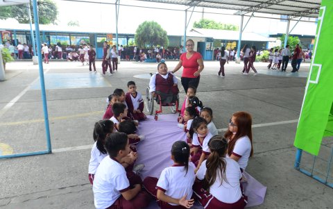 Compartir. Durante el recreo, la docente comparte juegos y vivencias con sus alumnos, en el patio del plantel.