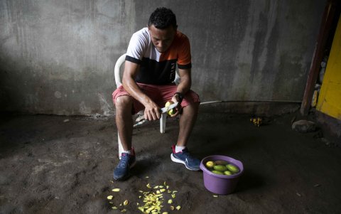 Alexander Mejía mientras prepara mangos para la venta ambulante en Managua, Nicaragua.