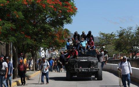 Un grupo de manifestantes conduce un vehículo blindado robado a las autoridades.