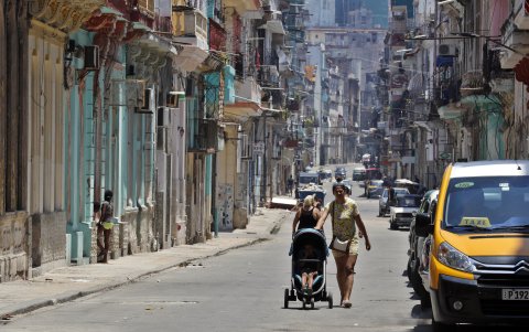 Una mujer camina con un coche para niño por una calle de la Habana (Cuba), este 11 de julio de 2023.