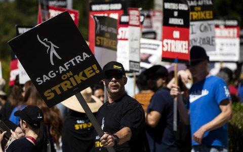 Miembros de la Federación Estadounidense de Artistas de Radio y Televisión (SAG-AFTRA) y del gremio de guionistas y escritores (WGA) fueron registrados este viernes, 14 de julio, al protestar frente a los estudios Paramount, en Los Ángeles (California, EE.UU.).