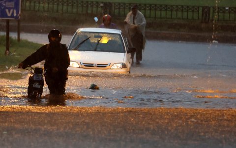 La gente se abre paso a través de una carretera inundada tras las fuertes lluvias monzónicas en Rawalpindi, Pakistán, el 19 de julio de 2023.