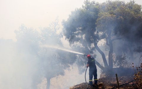 Un bombero intenta apagar un incendio forestal en la zona de Kandili Megara, en el oeste de Ática, Grecia, el 19 de julio de 2023.