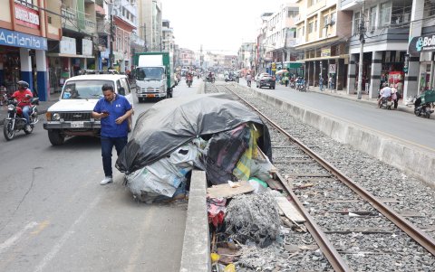 En el área de los carriles, una mujer y su hijo habitan en una covacha, lo que demuestra la situación de pobreza.