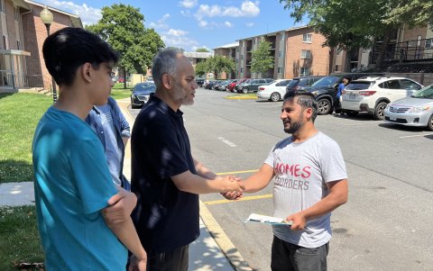 El afgano Nasser Haqparast (d), saluda a una familia de refugiados afganos a los que, junto a otros miembros del equipo de la ONG Homes Not Borders (Hogares No Fronteras).