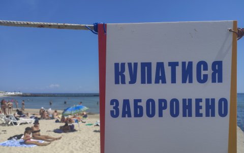 Un cartel avisa de la prohibición de bañarse en la entrada de una playa de Odesa.