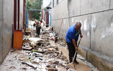 Las fuertes precipitaciones, han causado serios daños a viviendas. Varias personas limpian  los escombros