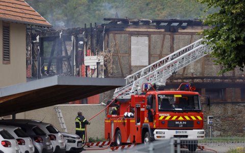 Los bomberos tratan de controlar el incendio en un albergue de Alsacia.