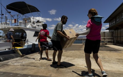 Un barco que trae donaciones de Ohau se descarga antes de ser cargado en camiones a Lahaina en el puerto de Maalaea, Hawai.