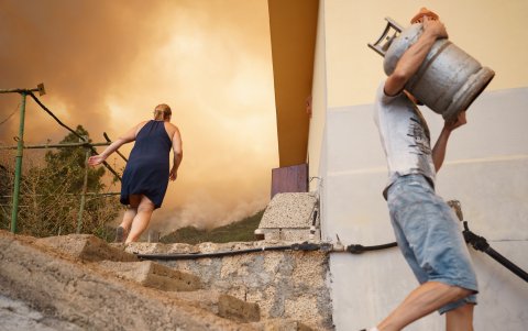 Vecinos de la zona del barrio de Los Margenes, en el pueblo de Igueste de Candelaria, evacuan los enseres de sus viviendas tras el aviso de desalojo de las autoridades por el incendio forestal.
