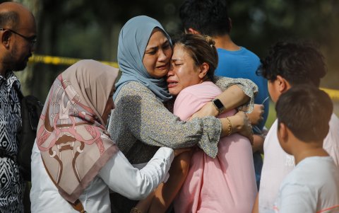 Familiares y parientes reaccionan en la escena del accidente de una avioneta en Elmina, estado de Selangor, Malasia, el 17 de agosto de 2023.
