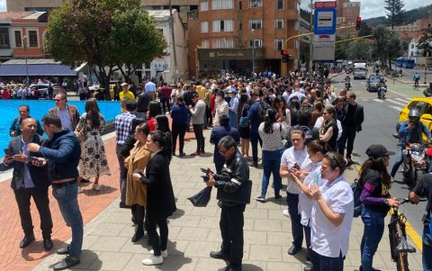 Personas se reúnen afuera de un edificio luego de ser evacuadas tras un temblor de 6.1 hoy, en Bogotá (Colombia).