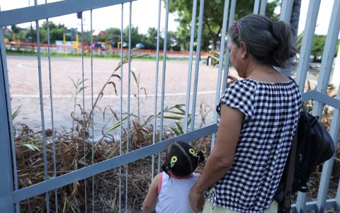 Público. Detrás de las rejas el público averigua cuándo se abren las puertas de los parques acuáticos.