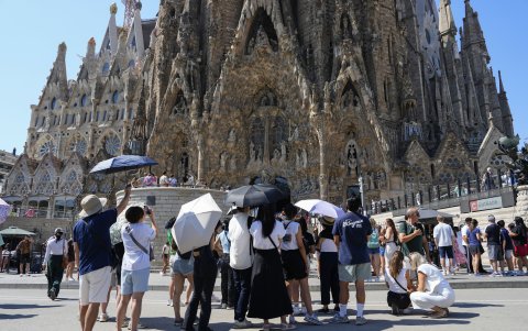 Varios turistas equipados con sombrillas visitan la Sagrada Familia, este miércoles en Barcelona.