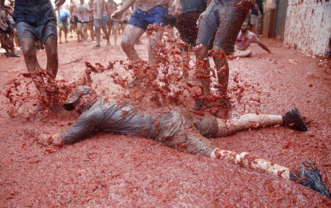 Un asistente al evento se baña en tomate sobre una calle de Buñol.