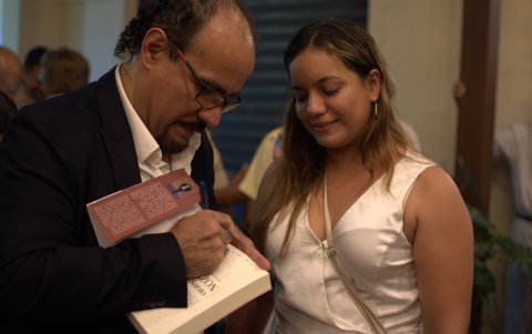 El investigador, folclorista y escritor guayaquileño Wilman Ordóñez Iturralde, firma una dedicatoria a una de las personas asistentes al lanzamiento del libro.