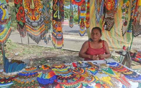 Marilyn de la nacionalidad kiwcha muestra un collar donde diseñó un ave en medio de rosas.