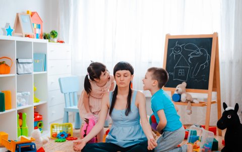 Una madre intenta relajarse junto a sus hijos pequeños en un estallido de impaciencia.