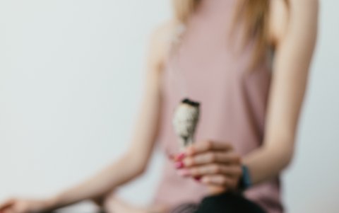 Mujer meditando en ambiente con decoración de estilo oriental