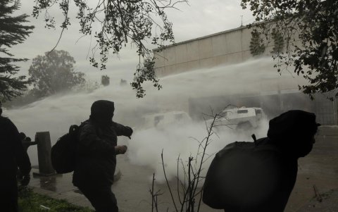 Encapuchados se enfrentan con policías durante una manifestación por los 50 años del golpe de estado contra el gobierno de Salvador Allende.