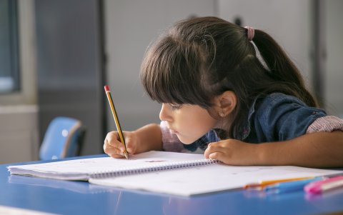 Escribir con el cuaderno demasiado cerca, uno de los indicadores de que los niños presentan un problema visual.