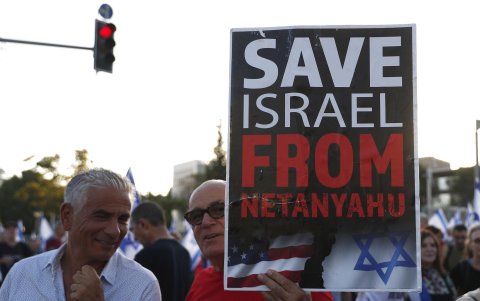 Ciudadanos muestran carteles en rechazo a la ley promulgada por el Gobierno de Netanyahu.