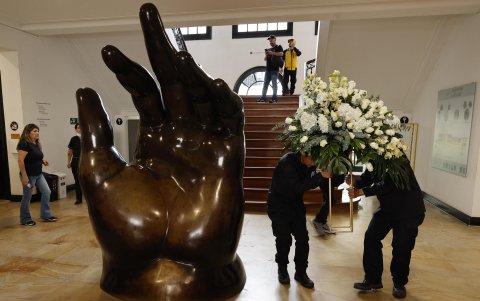 Empleados dejan un arreglo floral junto a la escultura La Mano de Fernando Botero, en el Museo Fernando Botero en Bogotá (Colombia).