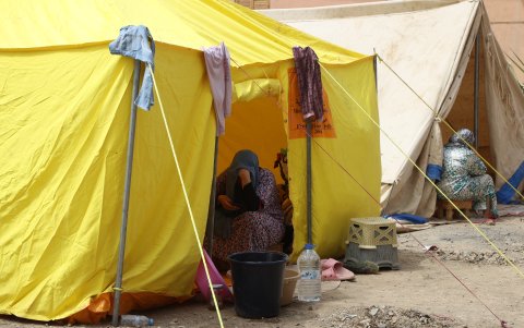 Una mujer se cobija a la sombra de una de las carpas de acogidas instaladas para los sobrevivientes del sismo en el pueblo Amizmiz.