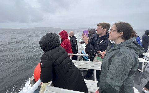 Un rupo de personas participa en una vuelta en barco por el Mar Céltico, organizada para presentar un proyecto que utiliza la IA para proteger a los cetáceos en las costas de Irlanda.