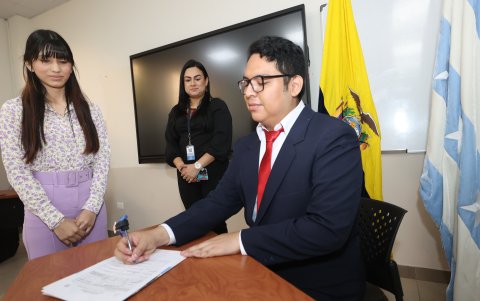 2. Feliz. Jaime Núñez firma el acta de titulación de licenciado en Administración de Empresas, junto a su compañera Tatiana Velasco.