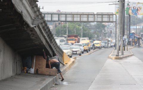En otro extremo del puente, un hombre ha creado su hogar, donde lava hasta la ropa.