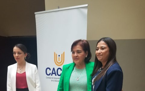 La presidenta del CACES posa para una foto con representantes de universidades que asistieron a la presentación.