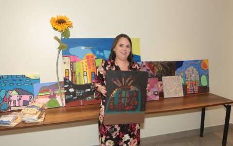 Karyna junto a los cuadros de su autoría que también fueron expuestos.