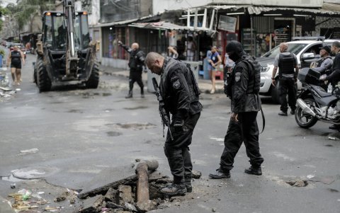 Policiales observan un hueco en la calle después de que fuera quitada una barra de refuerzo puesta por los narcotraficantes, durante un operativo contra las bandas criminales en Río de Janeiro.