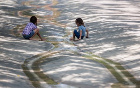 Dos niñas juegan en un riachuelo del Parc Central