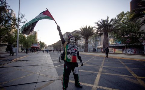 Una persona con la bandera de Palestina se manifiesta en la mítica plaza de Santiago, durante la conmemoración del cuarto aniversario del estallido social, en Santiago (Chile).