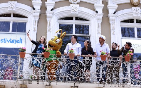 Autoridades en un balcón florido en Cuenca