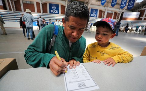Un ciudadano venezolano residente en Ecuador fue registrado este domingo, 22 de octubre, al votar, junto a un niño, en las elecciones primarias de la oposición, en Quito (Ecuador).