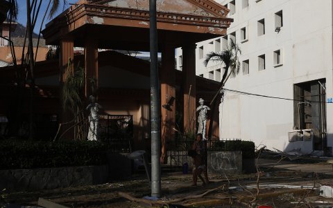 Una mujer y su hijo observan los escombros causados por el huracán Otis hoy