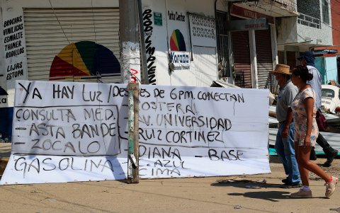 Fotografía de un cartel que anuncia servicio de luz y de gasolina hoy, tras el paso del huracán Otis en el balneario de Acapulco, en el estado de Guerrero (México).