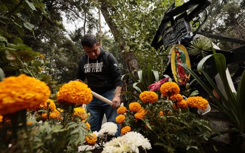 Cientos de personas acuden al Panteón de Xilotepec en la alcaldía de Xochimilco para limpiar y adornar las tumbas de sus difuntos y recibirlos en el Día de Muertos, en Ciudad de México (México).