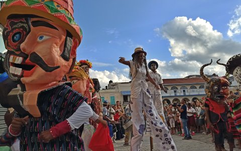 Personas participan en un desfile de carabelas por una calle, en La Habana (Cuba).
